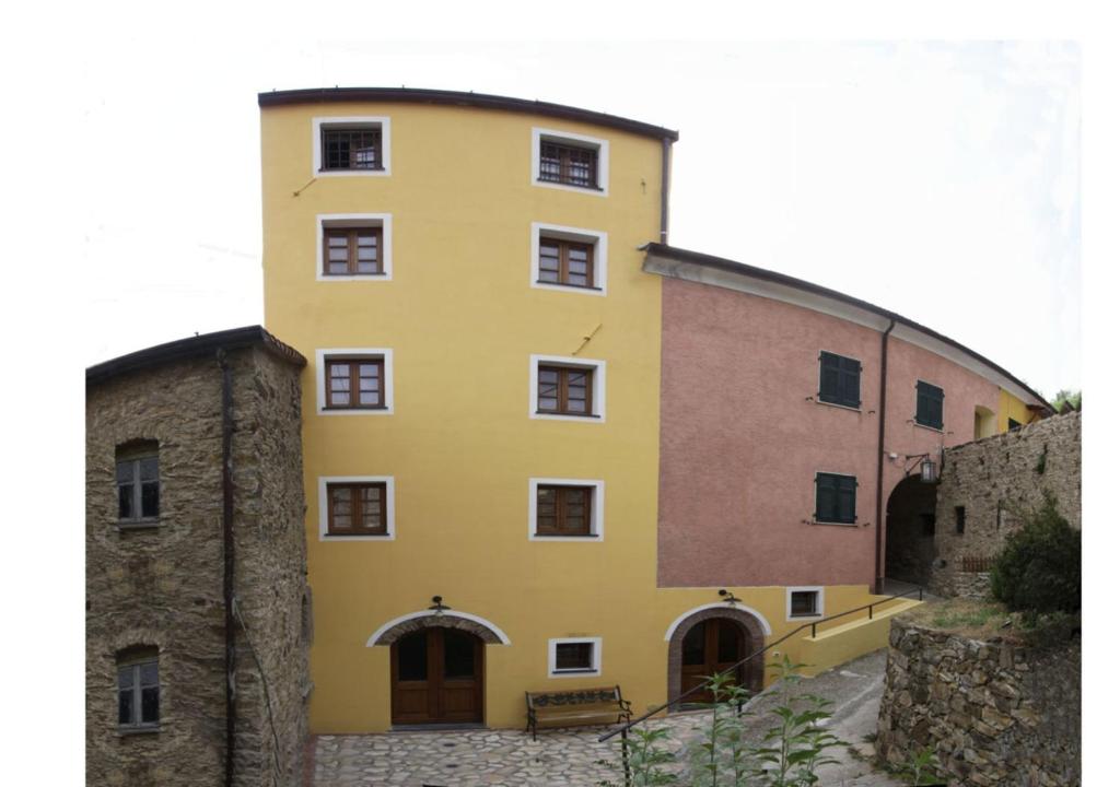 a yellow building next to a brick building at B&B Marina in Fosdinovo