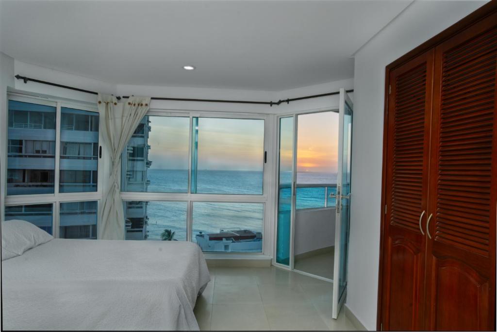 um quarto com uma cama e uma grande janela em Horizon Apartment em Cartagena das Índias