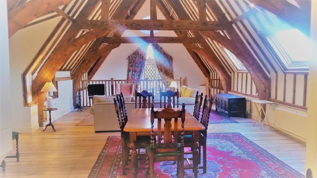 uma sala de jantar com uma mesa de madeira e cadeiras em Old School House em Bury Saint Edmunds