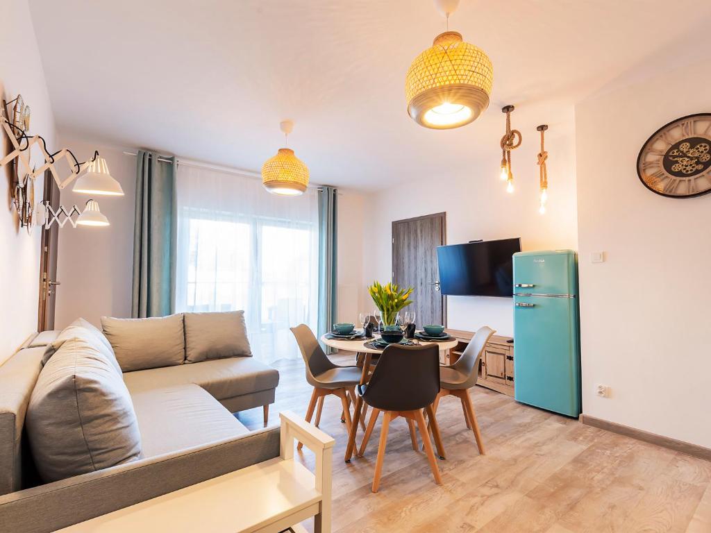 uma sala de estar com um sofá e uma mesa em VacationClub – 5 Mórz Sianożęty Apartament 1K/1 em Sianozety