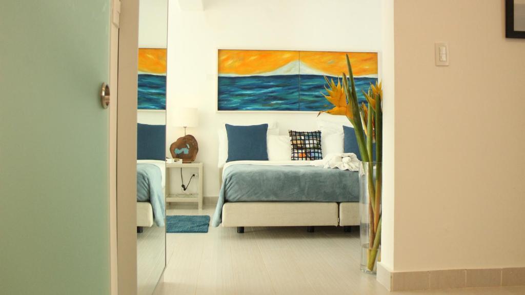a bedroom with a bed and a painting of the ocean at Casa Veintiuno in Sosúa