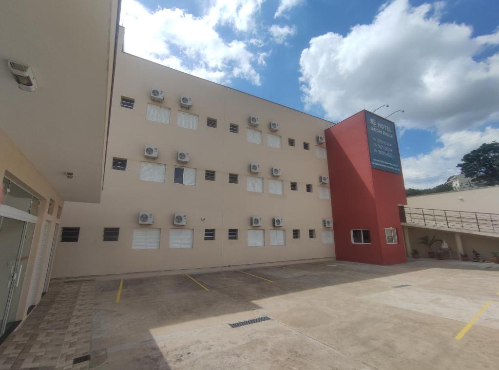 um grande edifício branco com um sinal vermelho em frente em Hotel Jardim Emilia Sorocaba em Sorocaba