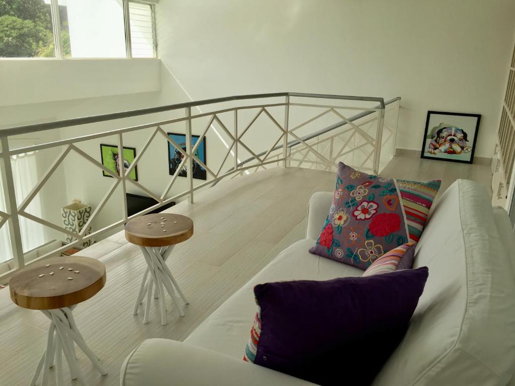 a living room with a white couch and two tables at Casa Veintiuno in Sosúa