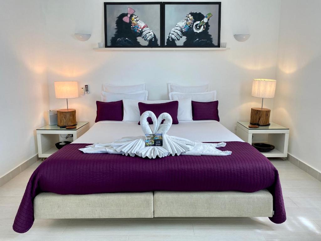 a bedroom with a bed with purple sheets and two lamps at Casa Veintiuno in Sosúa