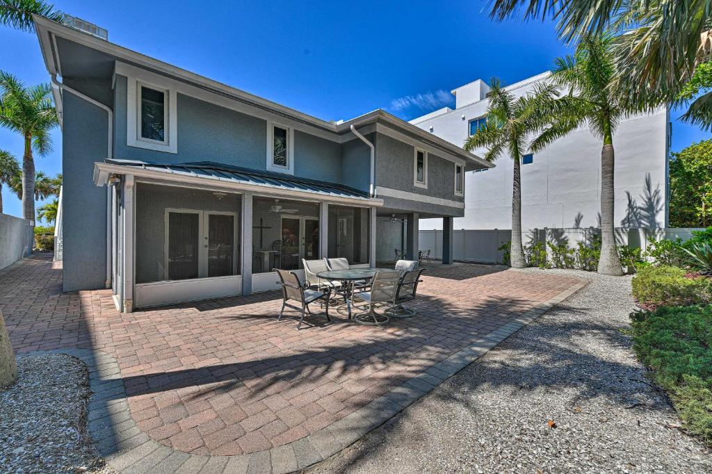 a house with a patio with a table and chairs at Lido Key Hideout with Patio and Yard and Walk to Beach! in Sarasota