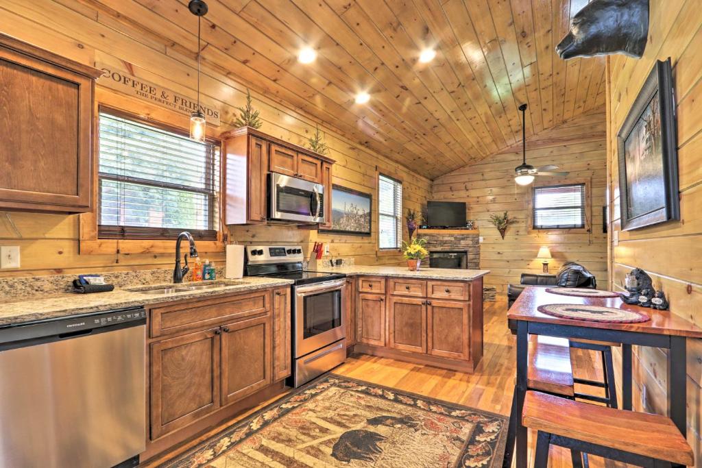 a large kitchen with wooden cabinets and a wooden floor at Rustic Pigeon Forge Cabin with Hot Tub Near Town! in Pigeon Forge