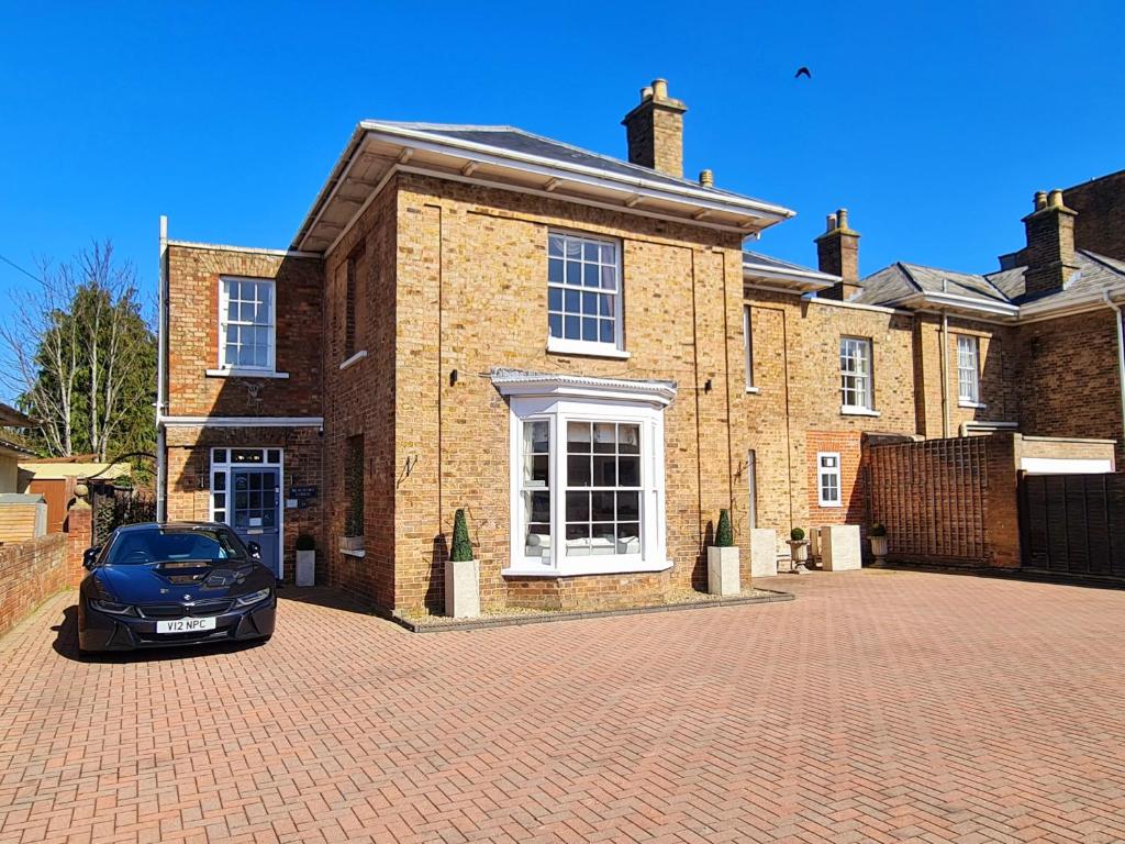 a car parked in front of a brick house at Beaufort Lodge in Taunton