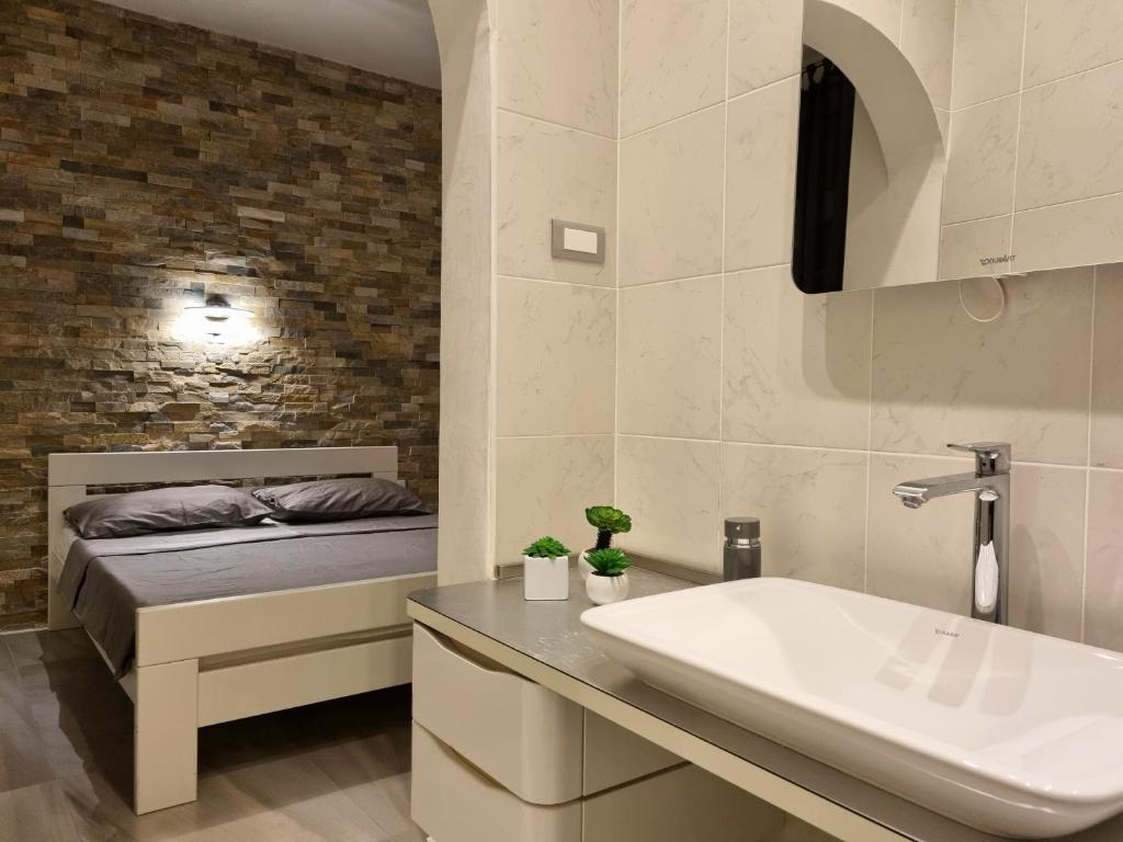 a bathroom with a sink and a bed at Apartment Amfiteatar in Pula