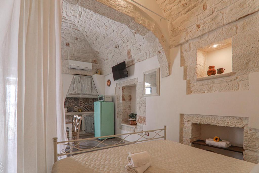 - une cuisine avec un lit et un mur en pierre dans l'établissement Domus Petra 104, à Ceglie Messapica