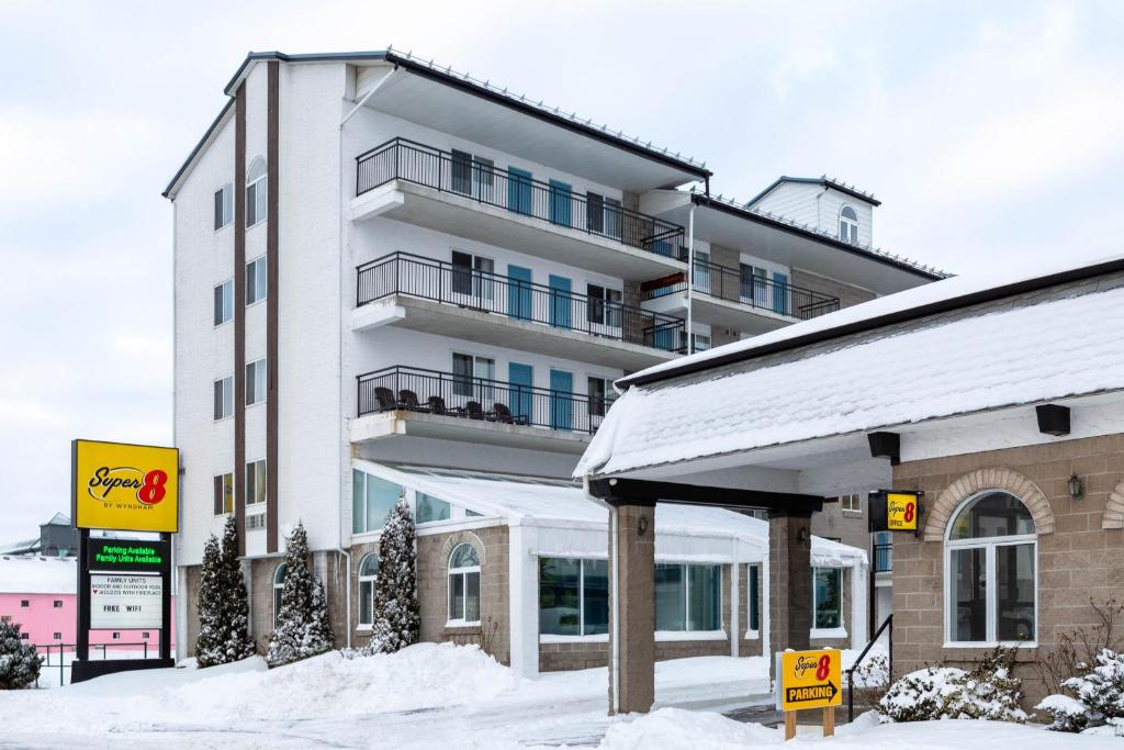 an apartment building with snow in front of it at Super 8 by Wyndham Niagara Falls by the Falls in Niagara Falls