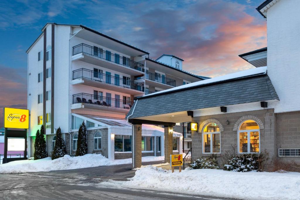 a white building with snow in front of it at Super 8 by Wyndham Niagara Falls by the Falls in Niagara Falls