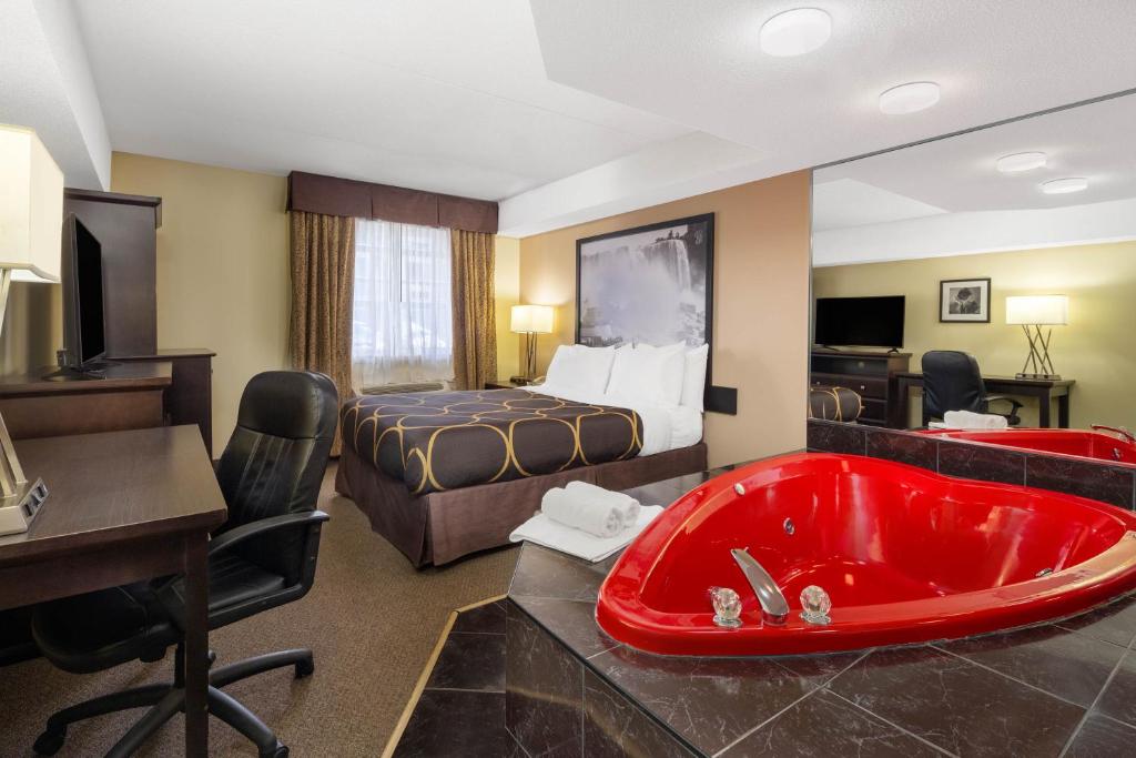 a hotel room with a red bath tub and a bed at Super 8 by Wyndham Niagara Falls by the Falls in Niagara Falls