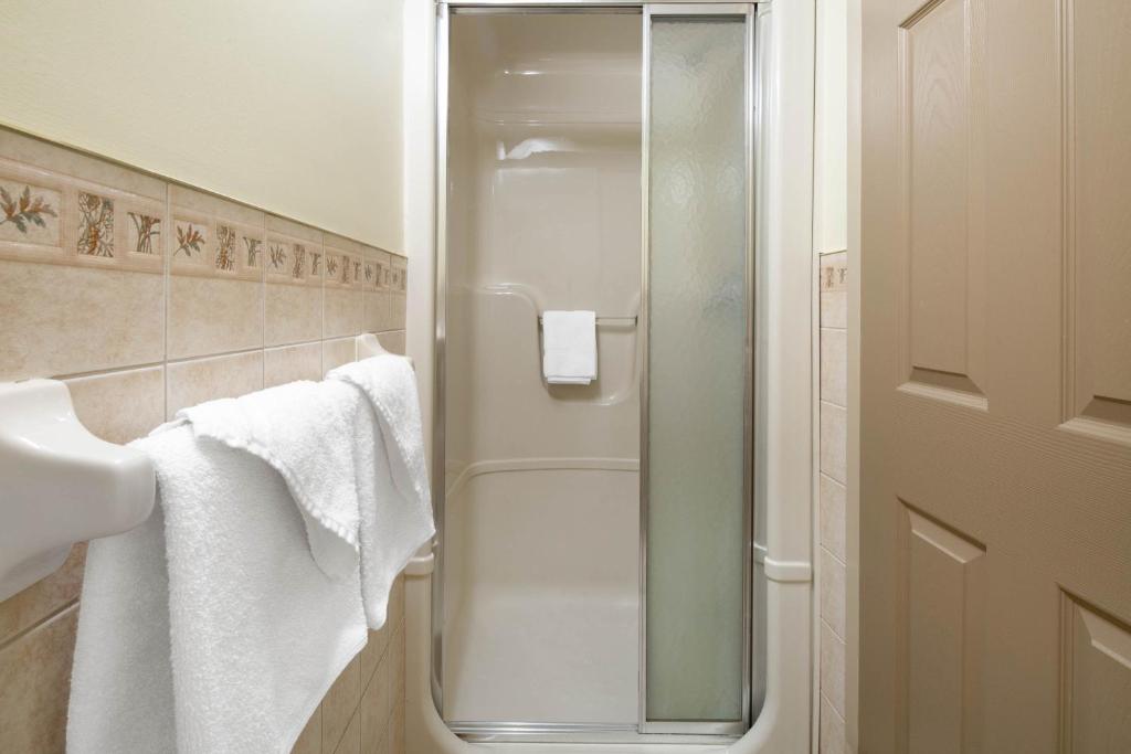a glass shower in a bathroom with towels at Super 8 by Wyndham Niagara Falls by the Falls in Niagara Falls