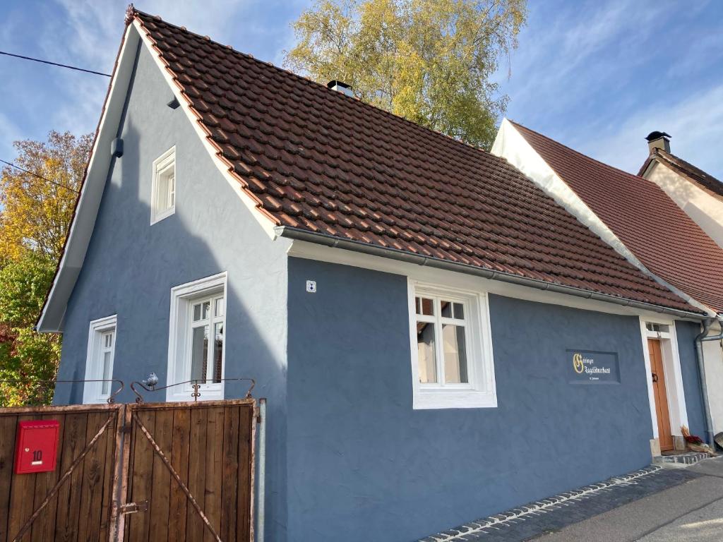 a blue and white house with a wooden fence at Historisches Tagelöhnerhaus in Geisingen