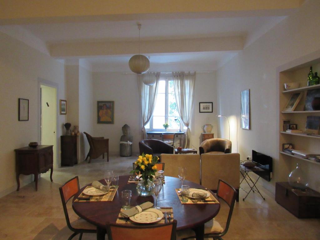 a living room with a table and chairs and a living room at Coeur de l'Arquet in LʼIsle-sur-la-Sorgue
