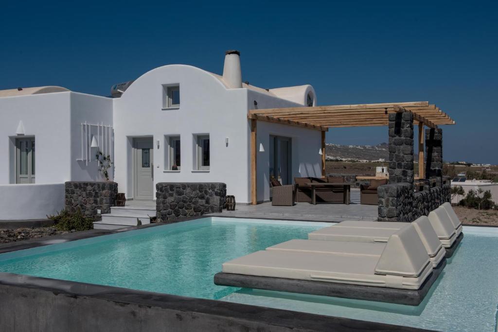 a villa with a swimming pool and a house at George Farm Land in Karterados