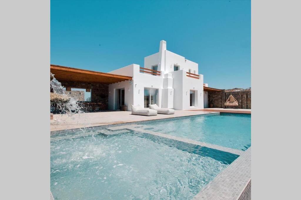 Villa con piscina frente a una casa en Blue Orchid Villa Mykonos, en Kalafatis