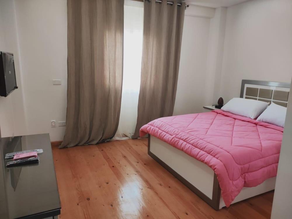 カイロにあるRamco For Furnished Apartments And Accommodation Compound Leilaのベッドルーム(ピンクの毛布付)