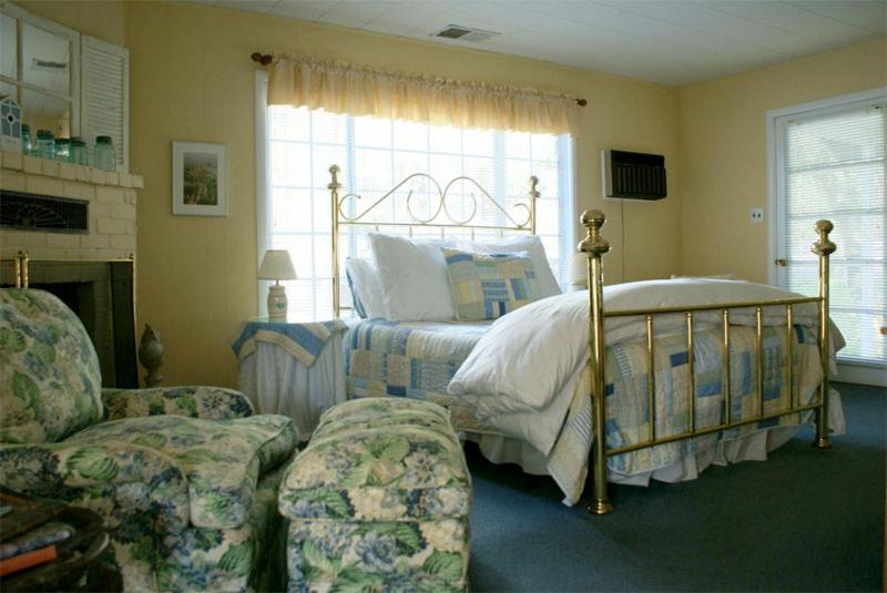 a bedroom with a bed and a couch and a chair at Trailside Inn Bed and Breakfast in Calistoga