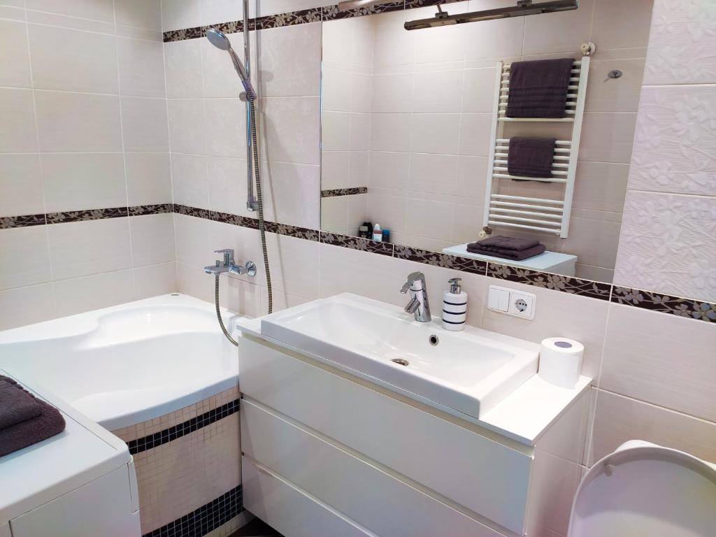 La salle de bains est pourvue d'un lavabo, de toilettes et d'une baignoire. dans l'établissement Nikoletos apartamentai, à Panevėžys
