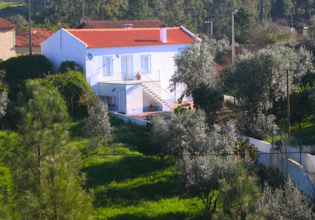 uma casa branca com um telhado vermelho numa colina em Casas d'Almofala em Vila de Rei