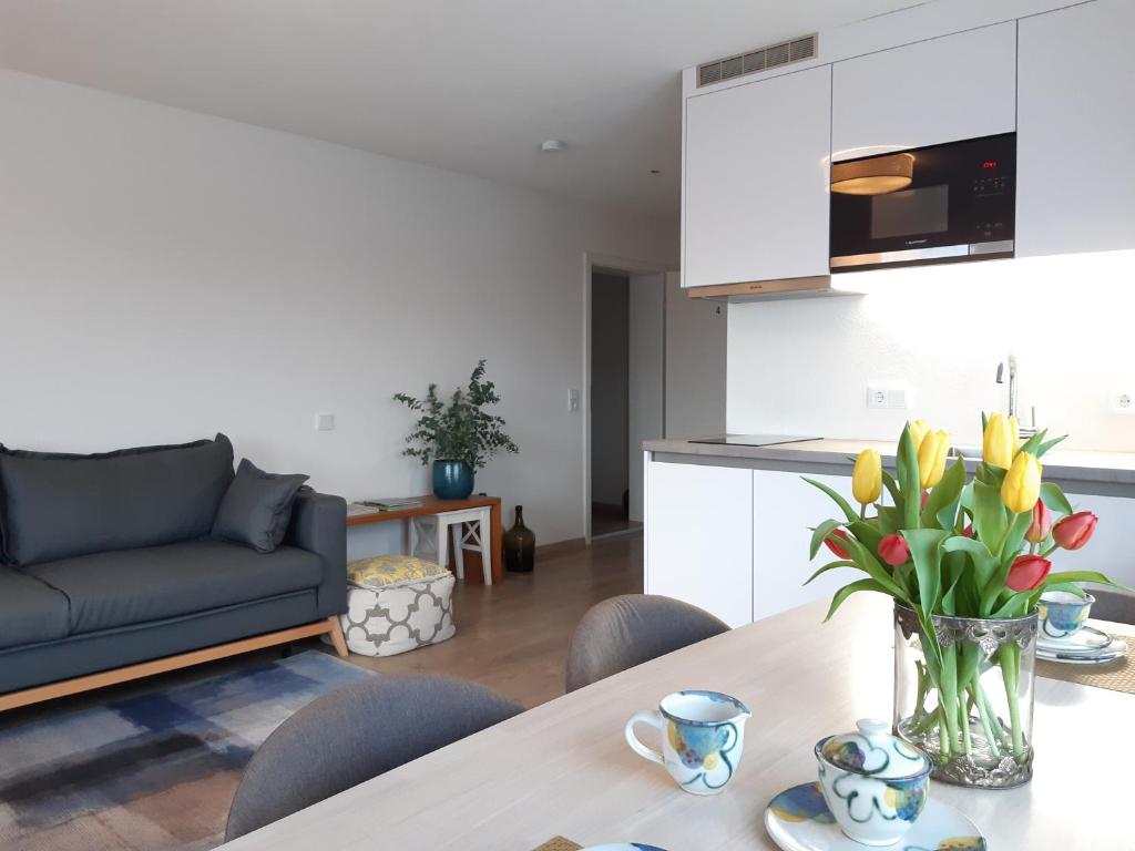 a kitchen and living room with a table and a couch at Apartment Gästehaus Maria in Rettenbach am Auerberg