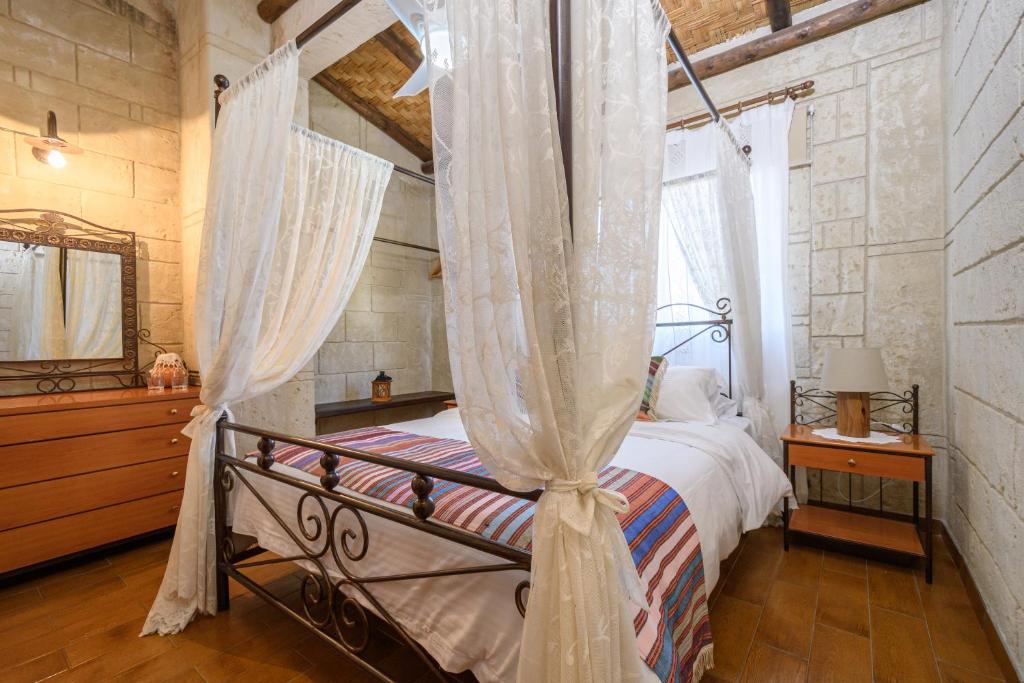 a bedroom with a canopy bed with curtains at Vasiliou House in Khandria
