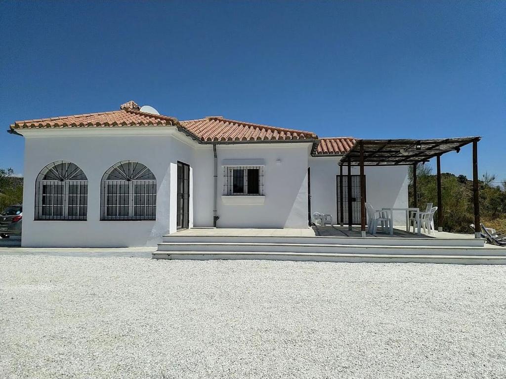 une maison blanche avec un toit dans une allée dans l'établissement Belvilla by OYO Casa de Aguila, à Almogía