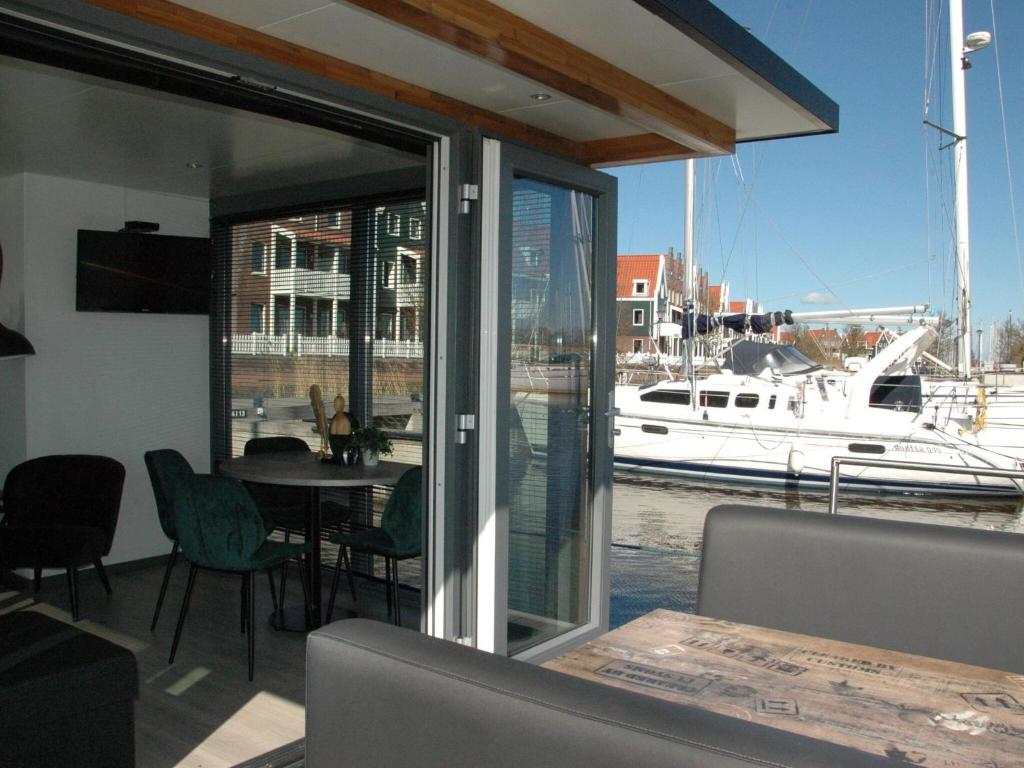 a dining room with a table and a boat in the water at Beautiful Houseboat in the harbour of Volendam near Centre in Volendam