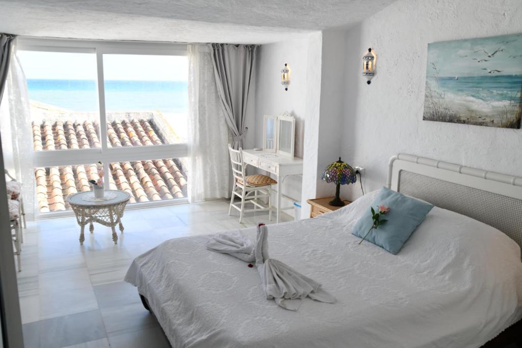 a bedroom with a bed and a view of the ocean at Sea shells at Bahia Dorada in Estepona