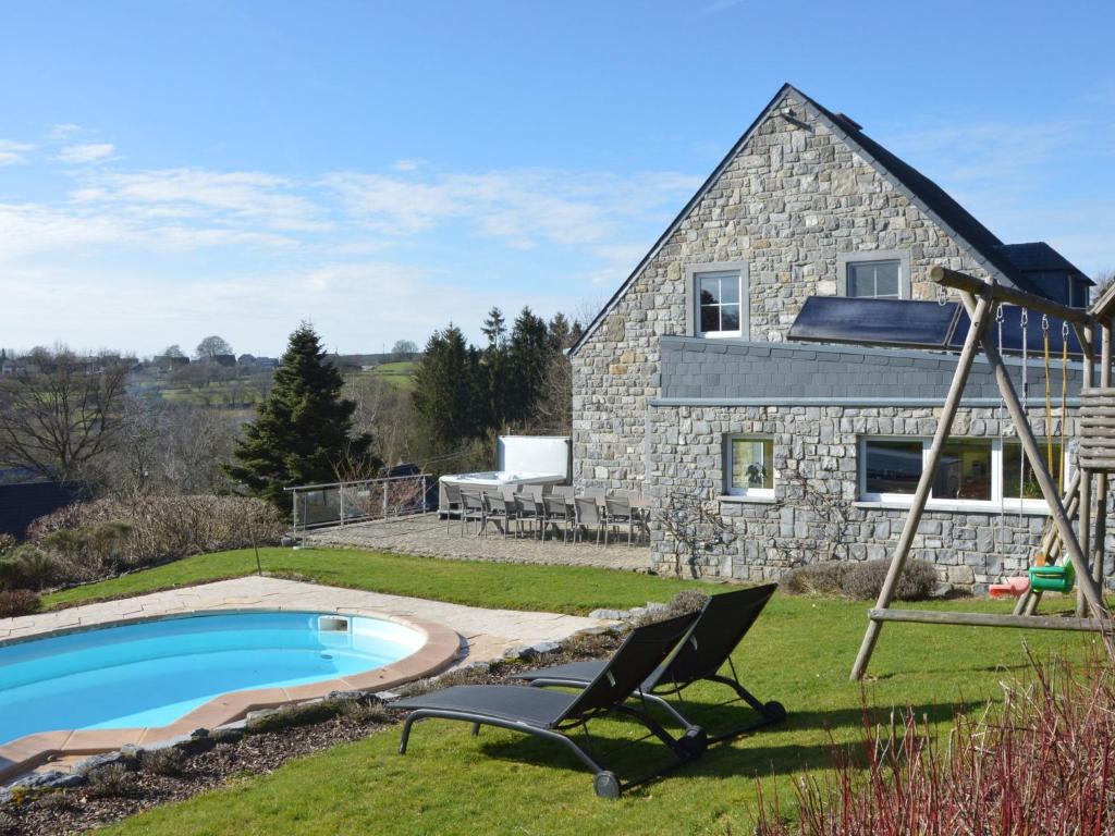 ein Steinhaus mit einem Pool und einer Schaukel in der Unterkunft Luxurious Villa in Stavelot with Sauna and Pool in Stavelot