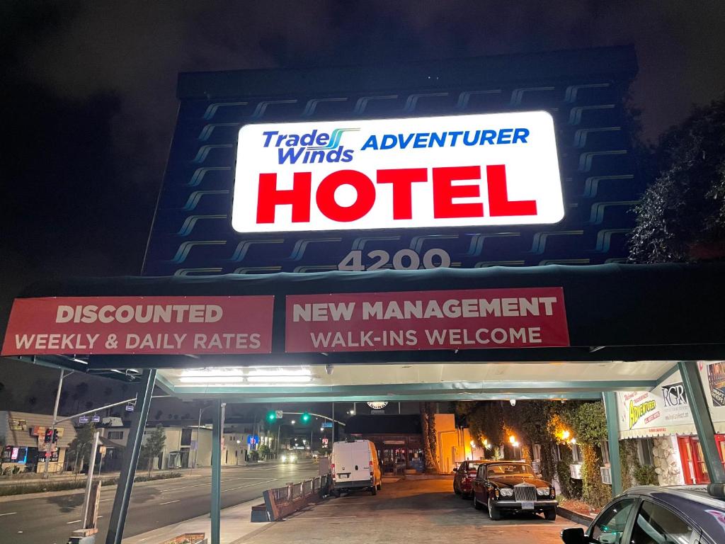 LA Adventurer Hotel في إنجلوود: علامة الفندق على موقف للسيارات في الليل