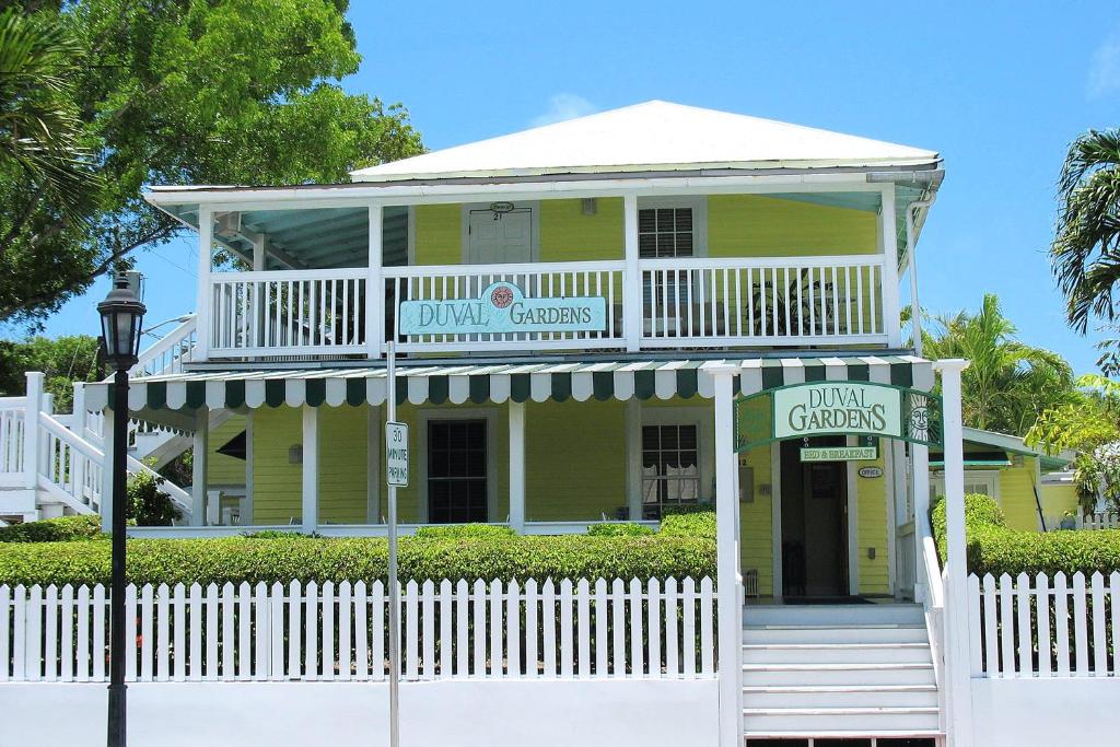 a white and green house with a blue roof at Duval Gardens in Key West