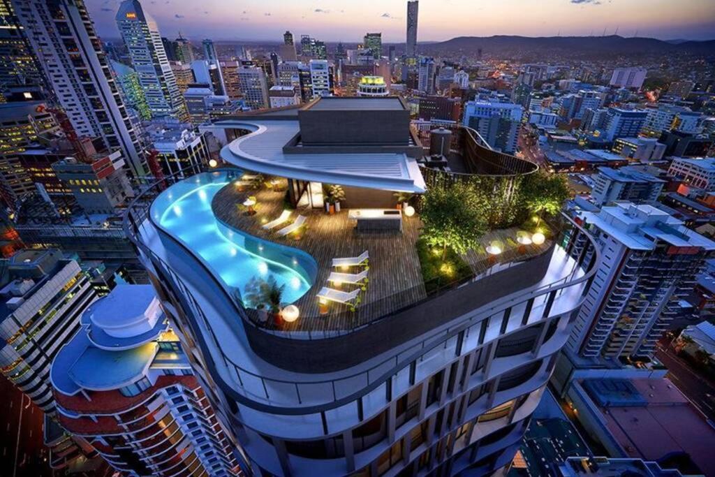 a building with a swimming pool on the top of it at Lvl 23 Spire Infinity Pool Netflix Wifi Carpark by Stylish Stays in Brisbane
