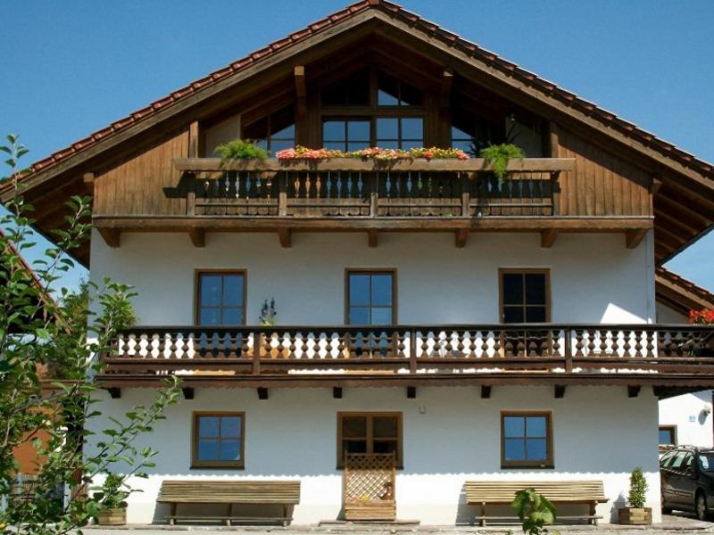 Ferienwohnung Mayer - Chiemgau Karte في انزل: مبنى به شرفة عليها نباتات
