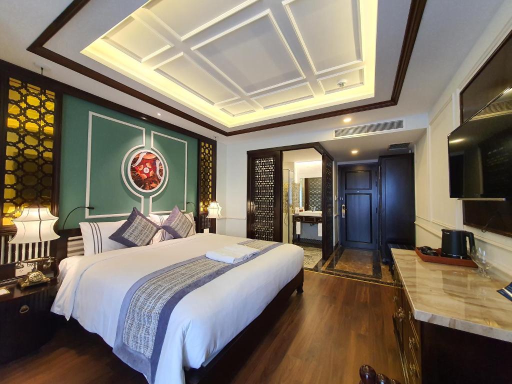 Postel nebo postele na pokoji v ubytování Le Pavillon Hoi An Gallery Hotel & Spa