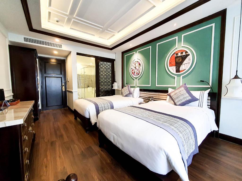 Postel nebo postele na pokoji v ubytování Le Pavillon Hoi An Gallery Hotel & Spa