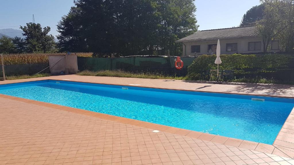 Arpiola的住宿－Appartamento in Toscana con Piscina e giardino，一座大蓝色游泳池,位于房子前