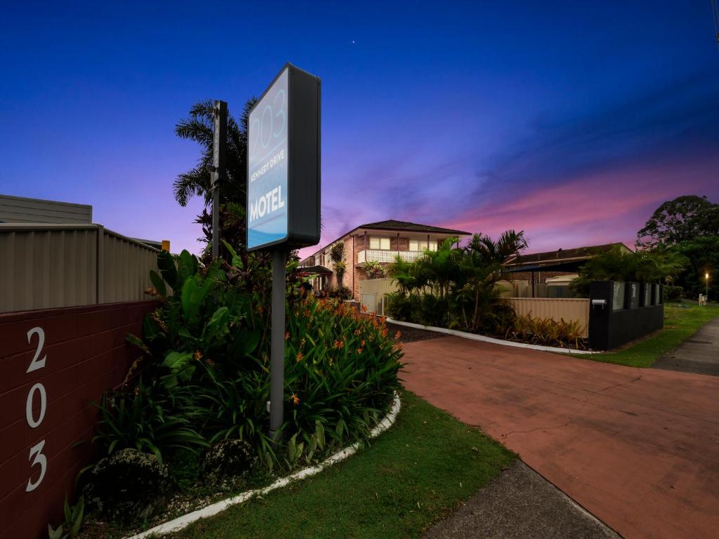 un cartel en un patio frente a un edificio en Kennedy Drive Airport Motel, en Tweed Heads