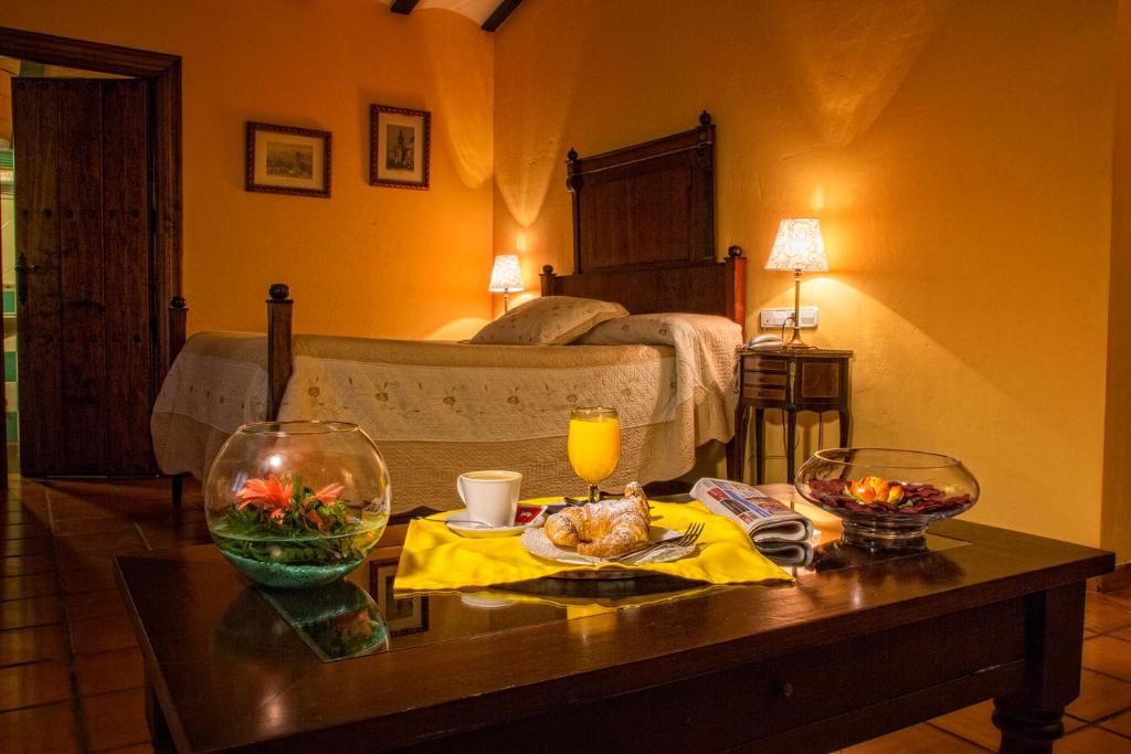 una habitación con una cama y una mesa con comida. en Hotel Bodega La Venta, en Casas de los Pinos