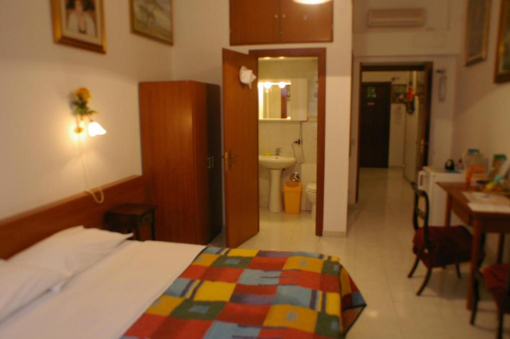 ローマにあるLe Rose di Biのベッドとバスルーム付きのホテルルームです。