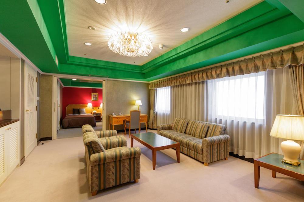 una camera d'albergo con soffitto verde e soggiorno di The Celecton Fukushima a Fukushima