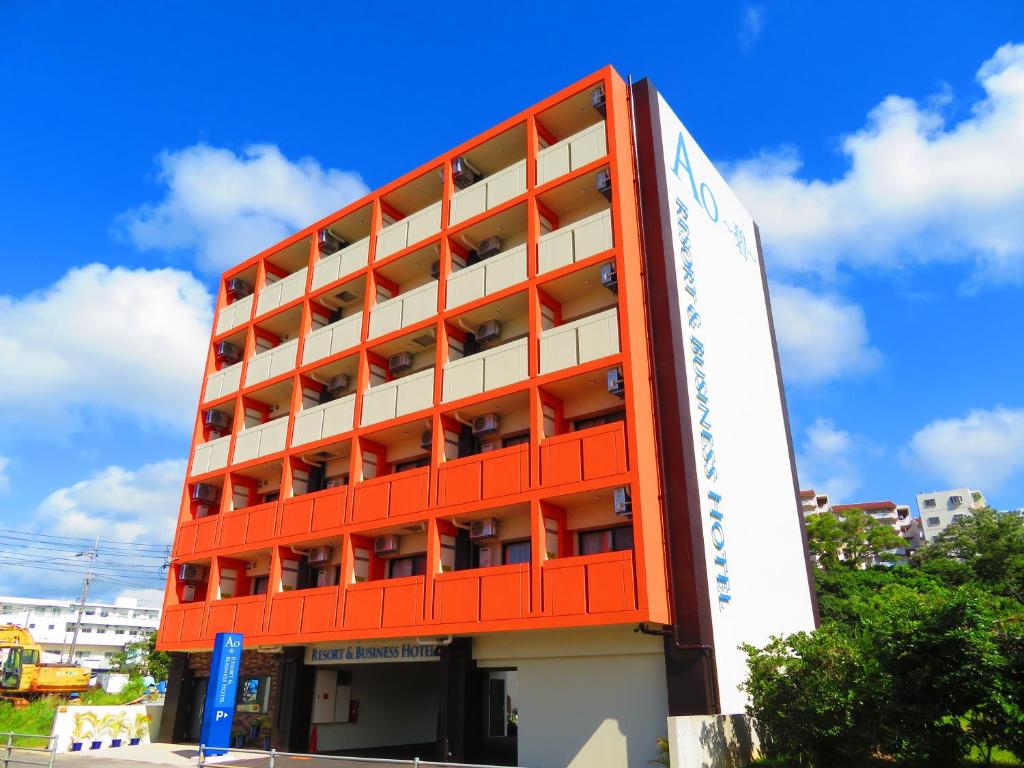 un immeuble d'appartements orange avec un panneau devant. dans l'établissement Ao Hotel, à Nago