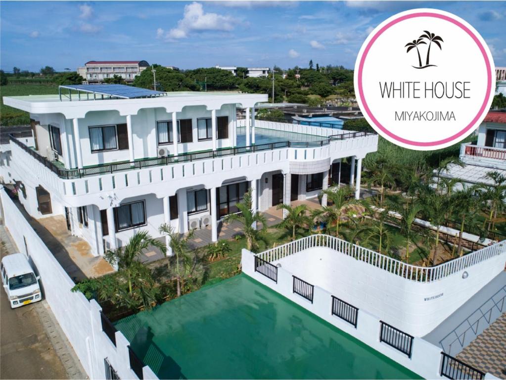 uma casa branca com piscina e uma villa em Miyakojima White House em Ilhas Miyako