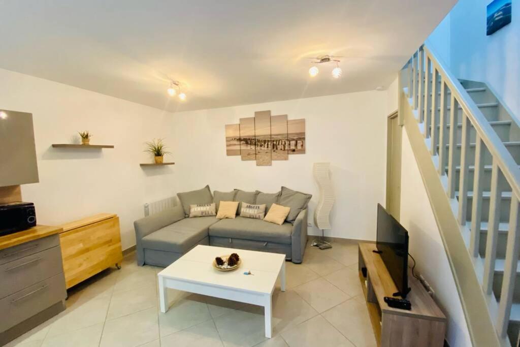 un salon avec un canapé et une télévision dans l'établissement Les pignots Logement T2 Bassin Arcachon, à Gujan-Mestras