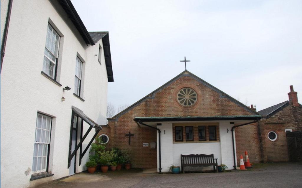 una iglesia con una cruz en la parte superior de un edificio en Dulverton Hostel en Dulverton