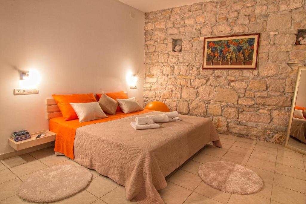 a bedroom with a bed and a stone wall at Split Inn Apartments in Split