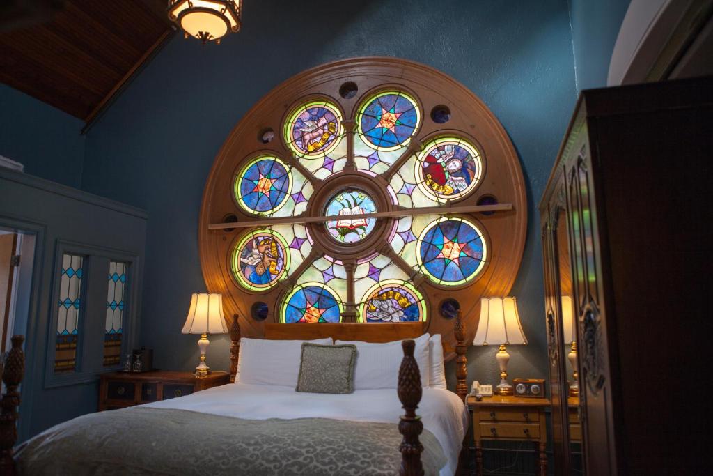a bedroom with a bed with a stained glass window at Belfry Inn and Bistro in Sandwich