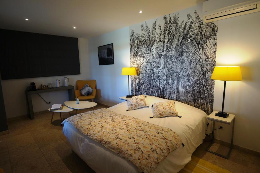 サントマリー・ド・ラメールにあるMas Lou Caloun - Chambre d'Hôte face à la piscine en Camargue - Les Saintes Maries de la Merのベッドと大画面スクリーン付きのホテルルームです。