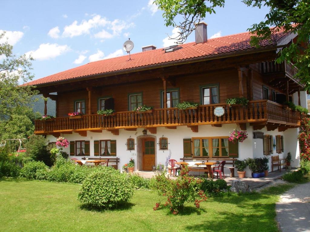 una grande casa in legno con portico e cortile di Ferienwohnung Rennerlehen a Schönau am Königssee